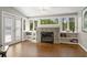 Cozy living room with a stone fireplace, built-in shelving, and natural light from large windows at 1724 Ridge Valley Nw Ct, Atlanta, GA 30327