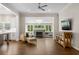 Spacious living room with a fireplace, hardwood floors, a ceiling fan, and a view into the sunroom at 1724 Ridge Valley Nw Ct, Atlanta, GA 30327