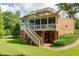 Expansive backyard featuring a screened porch with stairs leading down to a patio and lush green lawn at 981 Cranbrook Glen Ln, Snellville, GA 30078