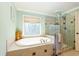 Bright bathroom with soaking tub, stylish glass shower, and a window offering natural light at 981 Cranbrook Glen Ln, Snellville, GA 30078