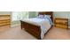 Bright bedroom featuring neutral carpeting, two wooden bookshelves, and a wood bed frame at 981 Cranbrook Glen Ln, Snellville, GA 30078