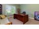 Home office with large desk, built in shelves, and natural light at 981 Cranbrook Glen Ln, Snellville, GA 30078