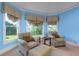 Bright seating area features comfortable striped chairs, an ottoman, and natural light from the windows at 981 Cranbrook Glen Ln, Snellville, GA 30078