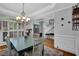 Elegant dining room featuring wainscoting, hardwood floors, modern chandelier, and ample natural light at 5355 Avonshire Ln, Cumming, GA 30040