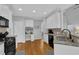 Well-lit kitchen features white cabinetry, stainless sink and built-in desk area at 5355 Avonshire Ln, Cumming, GA 30040