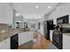 Bright kitchen boasts white cabinets, granite countertops and black appliances at 5355 Avonshire Ln, Cumming, GA 30040