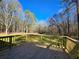 A spacious wooden back deck overlooks a lush green lawn and mature trees, perfect for relaxing and entertaining at 621 Hood Rd, Stockbridge, GA 30281