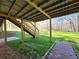 View of back yard with wooden stairs, grass, and trees at 621 Hood Rd, Stockbridge, GA 30281