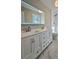Renovated bathroom features double sink vanity, an LED mirror, and marble-style floor tiles at 621 Hood Rd, Stockbridge, GA 30281