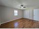 Bright bedroom features a modern ceiling fan, hardwood floors, and natural light from a large window at 621 Hood Rd, Stockbridge, GA 30281