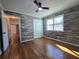 Bedroom featuring wood accent wall, hardwood flooring, ceiling fan, and a window view at 621 Hood Rd, Stockbridge, GA 30281