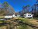 Lovely white home featuring a two-car garage, black shutters and a well-manicured lawn at 621 Hood Rd, Stockbridge, GA 30281