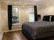 Bedroom with hardwood floors, two windows, and a comfortable bed with patterned bedding at 30 Woodbrook Ct, Mcdonough, GA 30252