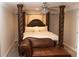 Bedroom featuring a four-poster bed and brown leather chaise lounge at 30 Woodbrook Ct, Mcdonough, GA 30252