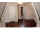 Open hallway space with dark hardwood flooring and a chandelier at 30 Woodbrook Ct, Mcdonough, GA 30252