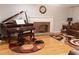 Comfortable living room featuring a piano, fireplace, hardwood floors, and a cozy rug at 30 Woodbrook Ct, Mcdonough, GA 30252