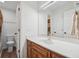 Bright bathroom with white countertop, warm wood cabinetry, toilet, and doorways at 950 Ivy St, Cumming, GA 30041