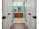 En suite bathroom with double doors and wood vanity with plenty of storage at 950 Ivy St, Cumming, GA 30041