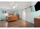 Cozy bedroom with wood floors, a ceiling fan, and a white sliding barn door at 950 Ivy St, Cumming, GA 30041