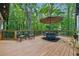 Wooden deck features an outdoor dining table and chairs with a wooded backdrop at 950 Ivy St, Cumming, GA 30041