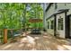 Spacious wooden deck with outdoor dining set, chairs, and wooded view at 950 Ivy St, Cumming, GA 30041