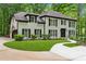 A traditional two-story brick house has a green lawn, mature landscaping, and a circular driveway at 950 Ivy St, Cumming, GA 30041