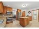 Traditional kitchen with wooden cabinets, granite countertops, stainless steel appliances, and tiled floors at 950 Ivy St, Cumming, GA 30041