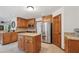 Well-lit kitchen boasts stainless steel appliances, wood cabinetry, and a central island with granite countertops at 950 Ivy St, Cumming, GA 30041
