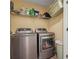 Modern laundry room with stainless steel washer and dryer, plus overhead shelving at 950 Ivy St, Cumming, GA 30041