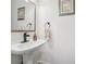 A small powder room features a pedestal sink with decorative hand towel and artwork at 950 Ivy St, Cumming, GA 30041