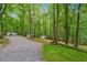 Gravel driveway leading to multiple small outbuildings surrounded by dense trees at 950 Ivy St, Cumming, GA 30041