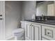 Elegant bathroom features a granite countertop, framed mirror and commode at 3107 Sandhurst Dr, Woodstock, GA 30189