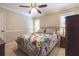 Cozy bedroom featuring a ceiling fan, a bed with colorful floral bedding, and bedside tables with lamps at 3107 Sandhurst Dr, Woodstock, GA 30189