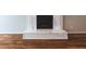 Close-up of a marble fireplace featuring a white mantel and dark firebox, complemented by hardwood flooring at 3107 Sandhurst Dr, Woodstock, GA 30189
