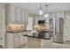 Stylish kitchen featuring white cabinets, black countertops, stainless steel appliances, and modern lighting at 3107 Sandhurst Dr, Woodstock, GA 30189