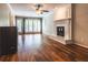 Bright living room featuring hardwood floors, a decorative fireplace, and access to the outdoor patio at 3107 Sandhurst Dr, Woodstock, GA 30189