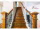 Beautiful staircase with wood steps, decorative iron railings, and detailed wood posts at 3107 Sandhurst Dr, Woodstock, GA 30189