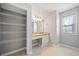 A closet and modern vanity with granite countertop is featured in this light grey bathroom at 3465 Maple Valley Dr, Cumming, GA 30040
