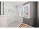 Modern bathroom with glass-enclosed shower, white tile, and a corner bench at 3465 Maple Valley Dr, Cumming, GA 30040