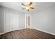Bedroom featuring a ceiling fan, closet, neutral walls, and wood-look floors at 3465 Maple Valley Dr, Cumming, GA 30040