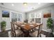 Cozy dining room featuring a wood table, neutral chairs, and natural light from surrounding windows at 3465 Maple Valley Dr, Cumming, GA 30040