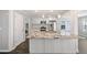 Kitchen island with granite countertops, stainless steel appliances, and white cabinetry, adjacent to laundry at 3465 Maple Valley Dr, Cumming, GA 30040