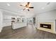Open-concept living space with fireplace, ceiling fan, and view into the kitchen with stainless appliances at 3465 Maple Valley Dr, Cumming, GA 30040