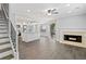 Spacious living area with an open kitchen, a fireplace, stairs and modern gray flooring at 3465 Maple Valley Dr, Cumming, GA 30040