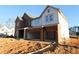 Exterior view of a two-story house with a brick and siding facade and a two-car garage at 456 Maypop Ln, Woodstock, GA 30188
