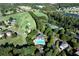 A bird's eye view of the golf course, tennis courts, lake, and pool surrounded by mature trees at 6335 Hampton Creek Dr, Cumming, GA 30041