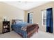 Cozy bedroom featuring a wood frame bed with a blue comforter, and natural light from two windows at 6335 Hampton Creek Dr, Cumming, GA 30041