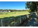 Picturesque golf course view with a white fence, lush green grass, and neighborhood homes at 6335 Hampton Creek Dr, Cumming, GA 30041