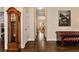 Hallway with hardwood floors featuring a grandfather clock, leading to an open-concept layout at 6335 Hampton Creek Dr, Cumming, GA 30041