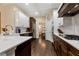Modern kitchen with stainless steel appliances, white marble countertops, and dark wood floors with a view to the dining room at 6335 Hampton Creek Dr, Cumming, GA 30041